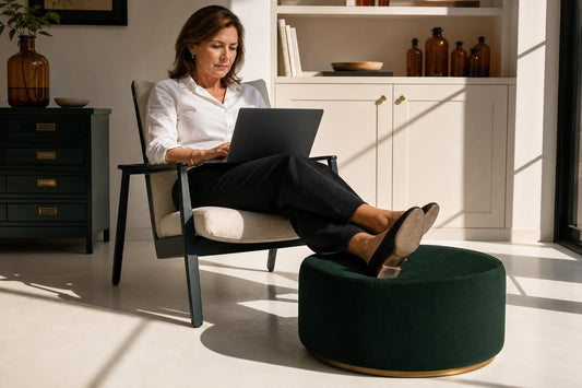 Femme d'âge mûr assise les pieds surélevés dans un intérieur lumineux